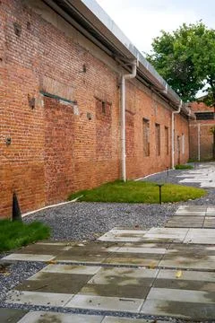 The stone walkway under the red brick exterior wall of the old machinery fa.. Stock Photos