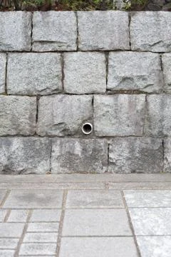 Stone wall and drain pipe Stock Photos
