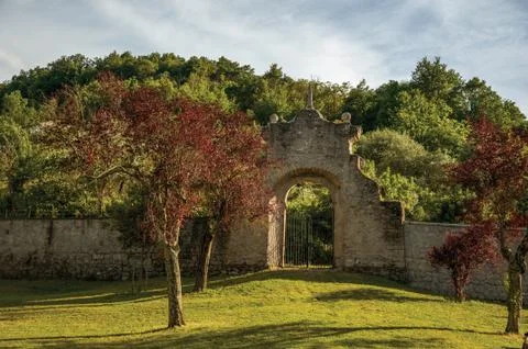 Stone wall and gate at sunset amidst the vegetation in the Park of Bomarzo Stock Photos