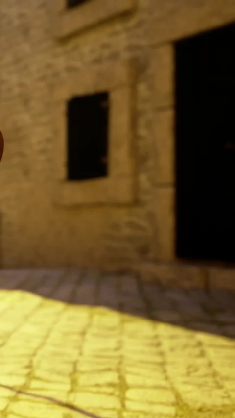 Stone wall and sunlight create pattern on pavement in small town square Stock Footage 331748219