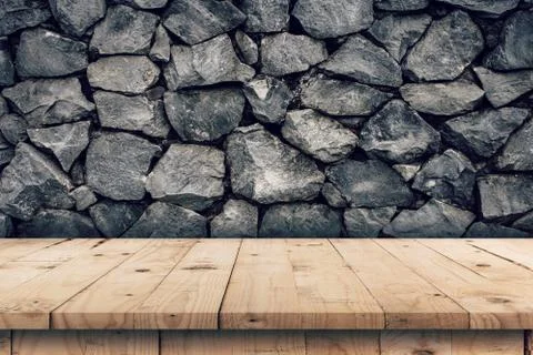 Stone wall background and empty wooden table display montage for product with Stock Photos