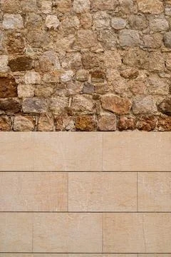 Stone wall background, divided into ancient and irregular stone and modern .. Stock Photos