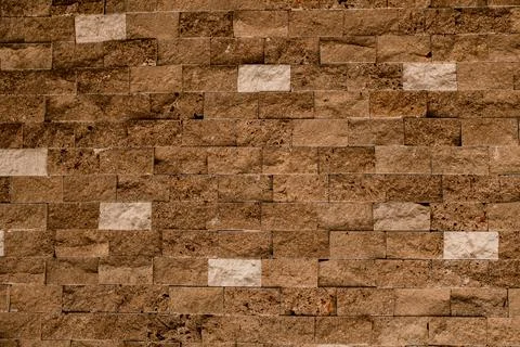 Stone wall as a background or texture. Beautiful brown shell bricks masonry. Stock Photos
