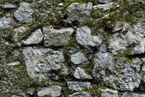 Stone wall as a background or texture. Moldy masonry. An example of masonry as a Stock Photos