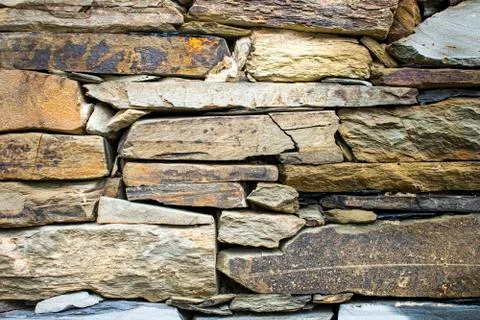 Stone wall built manually and in a traditional way without cement. Abstract b Stock Photos