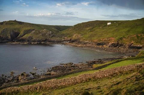 Stone wall at Cape Cornwall, in the background remains ruins of tin mine, copper Stock Photos