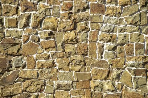 Stone wall of cobblestones background. View from the front. UNUSUAL SURFACE. Stock Photos