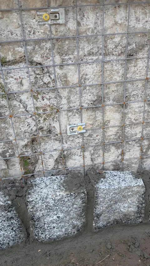 Stone Wall Construction with Wire Mesh Reinforcement Stock Footage 331090755