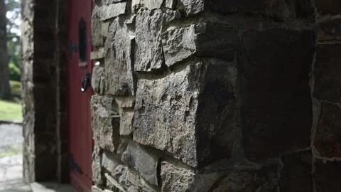Stone wall entrance with a red door moving shadows Stock Footage 341908182