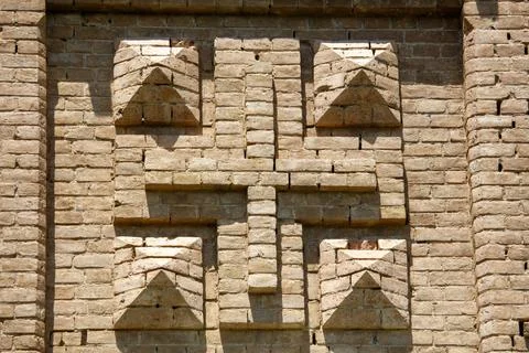 Stone wall features geometric brick pattern with triangular shapes Stock Photos