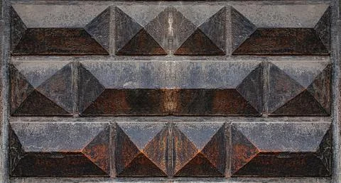 A stone wall featuring a textured geometric pattern of symmetrical diamond and Stock Photos