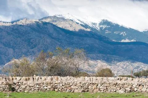Stone wall in the field. In the background, can be seen La Pedriza Stock Photos