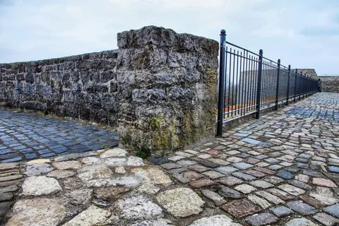 A stone wall with a gate in the middle Stock Photos