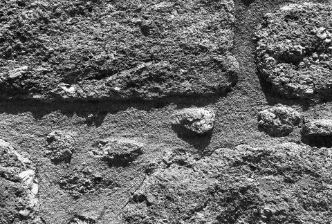 Stone wall with grey textured surface. Old weathered rock pattern with rough Stock Photos