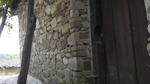 The stone wall of the house and the roof, braided with grapevine. Stock Footage 80248853