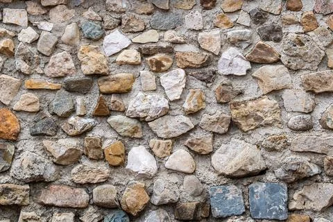 Stone wall of large rounded mounds of various colors. Stock Photos