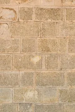Stone wall with light beige blocks. vertical pattern solid hard background Foto stock