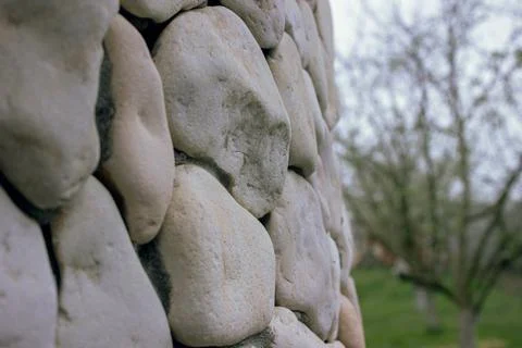 Stone wall made of rounded light boulders in close up Stock Photos
