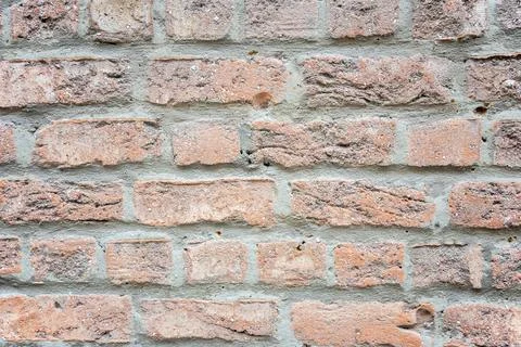 Stone wall with much brown bricks of the modern building. Stock Photos