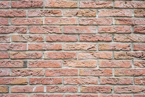 Stone wall with much brown bricks of the modern building. Stock Photos