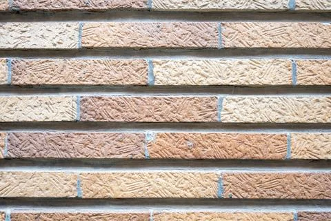 Stone wall with much brown bricks of the modern building. Stock Photos