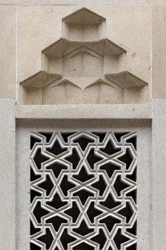 Stone wall panel featuring intricate geometric patterns, Arabic windwo Stock Photos