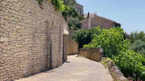 Stone wall path moving trees Gordes Village deeo blue sky Stock Footage 250264879