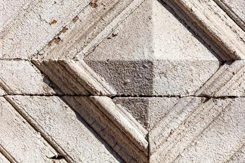 A stone wall with a pattern of squares and triangles 写真素材