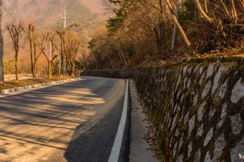 Stone wall on side of road. Stock Photos