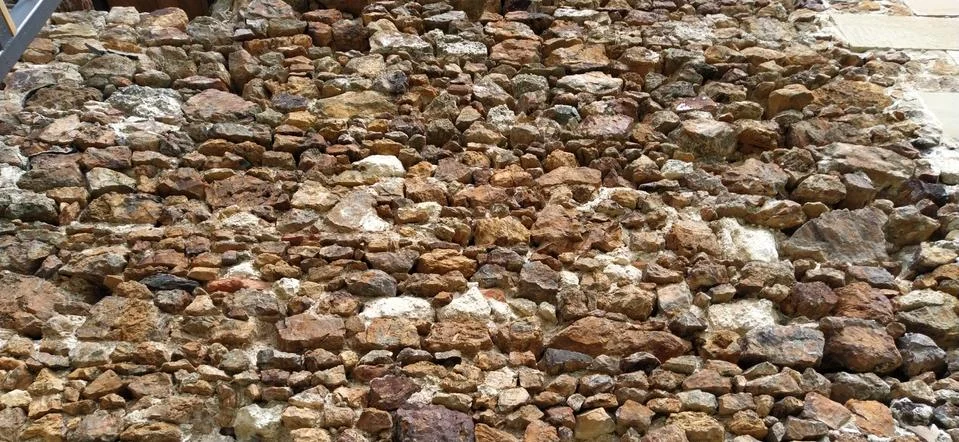 Stone wall. Stacked large bricks and cobblestones in warm colors. Loose white 写真素材