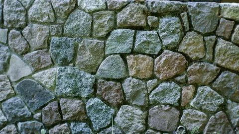 Stone wall texture background. The wall of the building is lined with stones Stock Photos