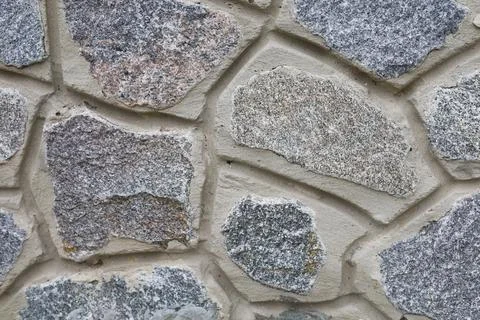 Stone wall texture of different forms stones. Wall cladding with granite ston Stock Photos