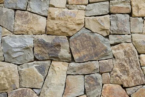 Stone wall texture handmade of rough blocks Stock Photos