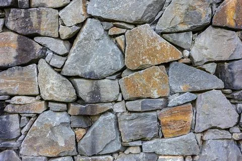 Stone wall texture with irregularly shaped rocks and stones Foto stock