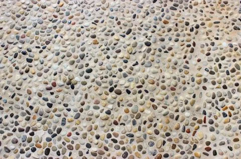 Stone wall texture, road made of small round and sea stones Stock Photos