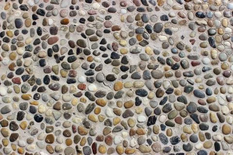 Stone wall texture, road made of small round and sea stones Stock Photos