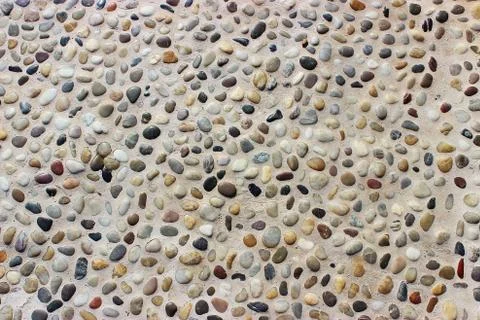 Stone wall texture, road made of small round and sea stones Stock Photos