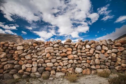 The stone wall under the cloudy sky. Background. Stock-Fotos