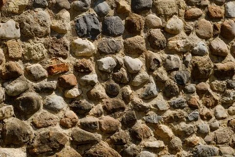 Stone wall with various shapes and colors in outdoor setting Stock Photos