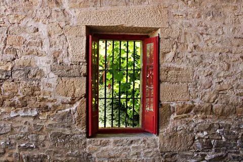 Stone wall with a window and red shutters looks at the vineyard. Elciego, Spa Stock Photos