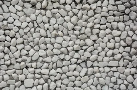 Stone wallTexture consisting of small pebbles embedded in cement. Background. Stock Photos