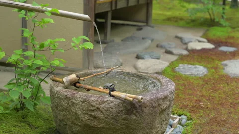 Stone water basin with bamboo pipe. Japanese garden motif. Stock Footage 164814922