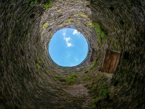Stone well interior looking up at blue sky Stock Photos