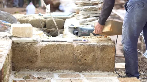 A stonecutter or stonemason is profiling the cut of a stone with a wide chisel. Vidéo 84153503