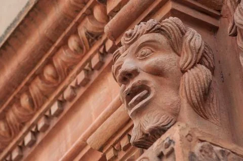 Stoned head on building facade Stock Photos