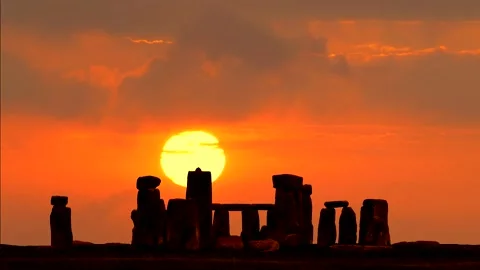 Stonehenge at sunrise - colorful clouds in time lapse in background Stock Footage