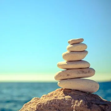 Stones balance at the beach, stack over blue sea Stock Photos