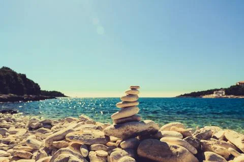 Stones balance, pebbles stack over blue sea in Croatia. Stock Photos