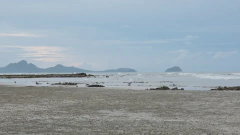 Stones beach background and texture. Rocks on the beach and sea waves at sunset. Stock Footage 204450442