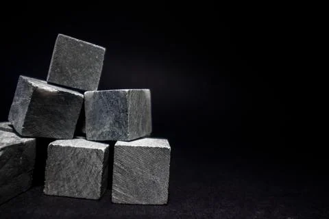 Stones for cooling drinks in the form of a pyramid stand on a dark background. Stock Photos